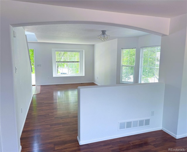 20401 E Chenango Pl, Aurora, CO 80015 - spare room with dark wood-type flooring, a chandelier, and arched walkways