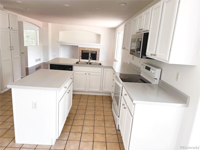 20401 E Chenango Pl, Aurora, CO 80015 - kitchen with stainless steel microwave, white electric range oven, white cabinetry, light tile patterned flooring, and recessed lighting
