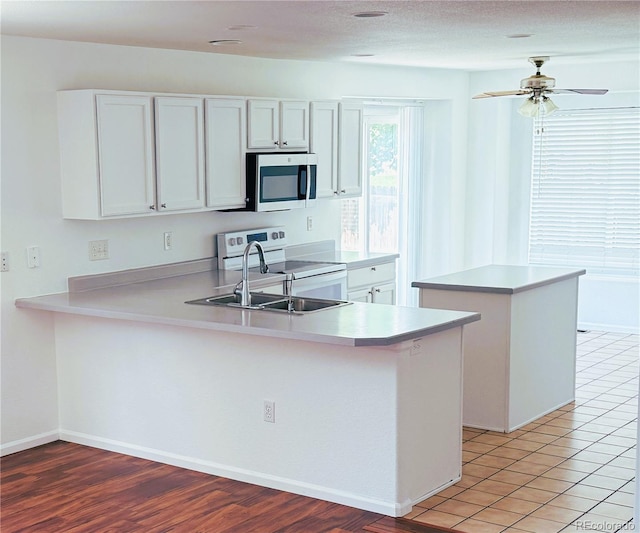 20401 E Chenango Pl, Aurora, CO 80015 - kitchen with stainless steel microwave, electric range, a peninsula, light countertops, and ceiling fan