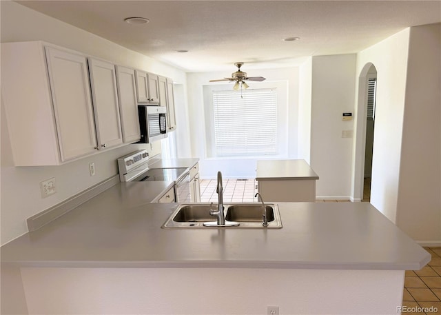 20401 E Chenango Pl, Aurora, CO 80015 - kitchen with range with electric stovetop, stainless steel microwave, a peninsula, arched walkways, and ceiling fan