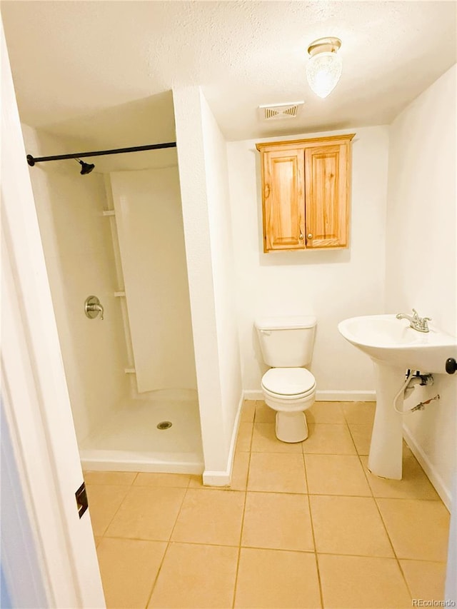 20401 E Chenango Pl, Aurora, CO 80015 - full bathroom featuring tile patterned flooring, a shower stall, and a textured ceiling