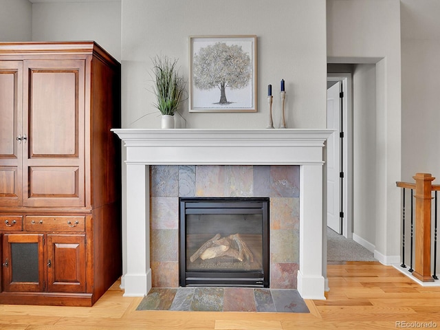 details featuring hardwood / wood-style flooring and a tile fireplace