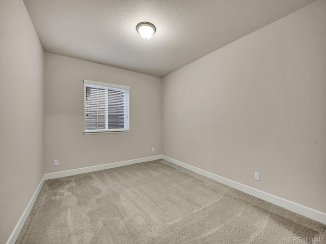 carpeted empty room featuring a textured ceiling