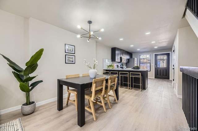 dining area featuring light wood-type flooring, an inviting chandelier, baseboards, and recessed lighting