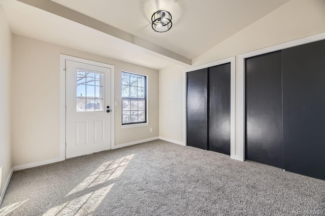 interior space featuring lofted ceiling, carpet, and baseboards