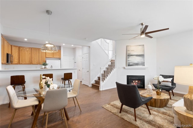 dining room featuring recessed lighting, stairway, wood finished floors, a ceiling fan, and baseboards
