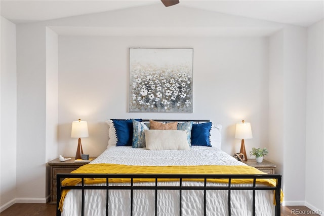 bedroom with baseboards, lofted ceiling, and wood finished floors