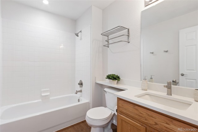 bathroom with shower / bathing tub combination, wood finished floors, vanity, and toilet