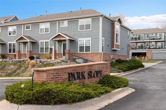 view of front of property featuring brick siding and cooling unit