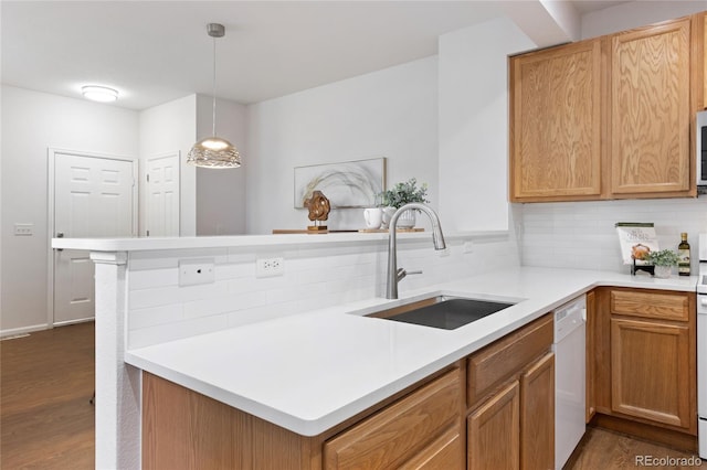 kitchen featuring dark wood finished floors, dishwasher, decorative backsplash, and a sink