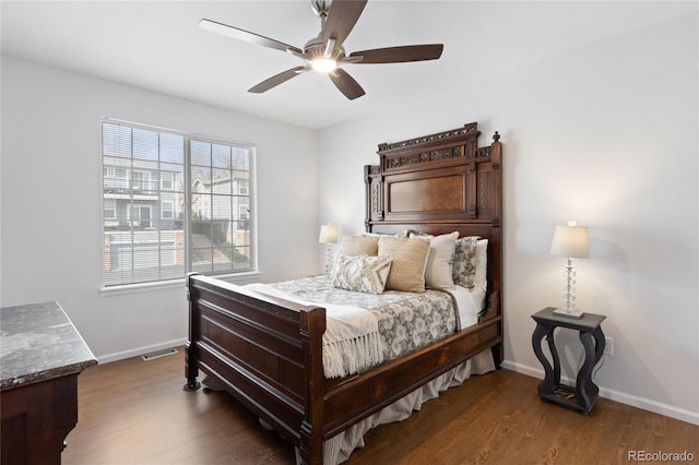 bedroom with baseboards, wood finished floors, visible vents, and a ceiling fan