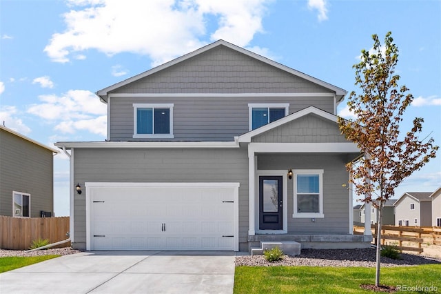 view of front of house featuring fence, a garage, and driveway