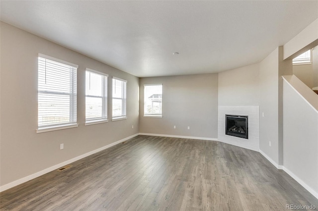 unfurnished living room featuring a healthy amount of sunlight and hardwood / wood-style flooring