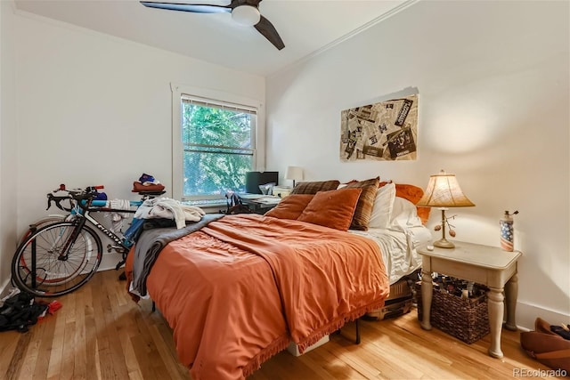 bedroom with crown molding, ceiling fan, and light hardwood / wood-style floors