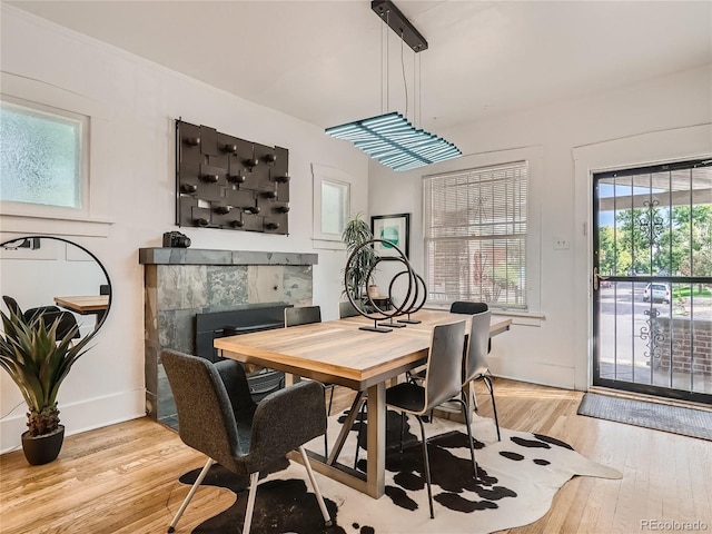 dining space featuring light hardwood / wood-style floors and a tile fireplace