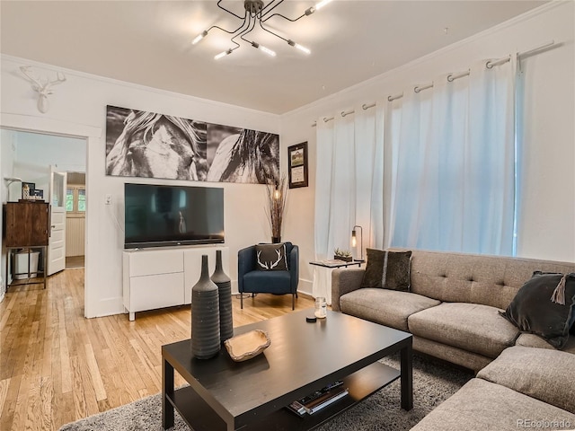 living room with crown molding and light hardwood / wood-style flooring