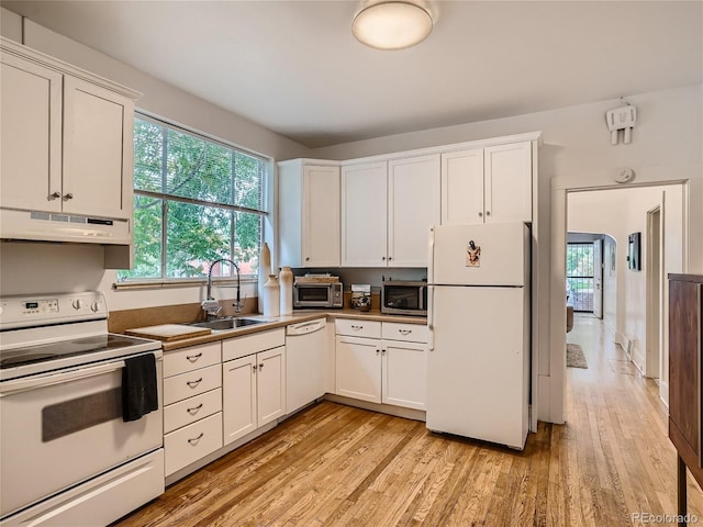 kitchen with white cabinetry, sink, white appliances, and light wood-type flooring