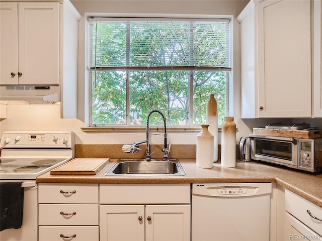 kitchen featuring white cabinetry, sink, and white appliances