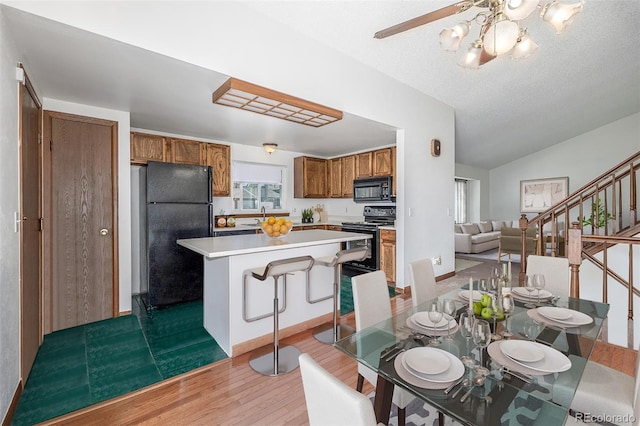 18083 E Atlantic Dr, Aurora, CO 80013 - dining space with wood finished floors, vaulted ceiling, a ceiling fan, and stairs