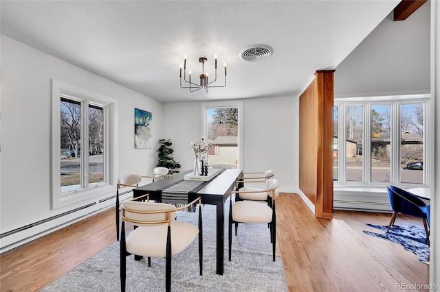 dining room with light hardwood / wood-style floors, an inviting chandelier, and a baseboard heating unit