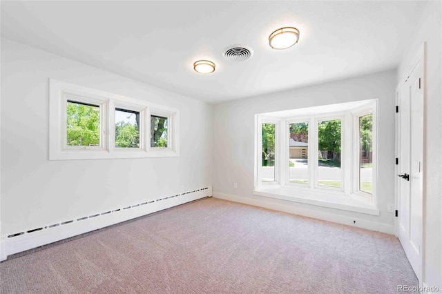 carpeted empty room with baseboard heating and a healthy amount of sunlight