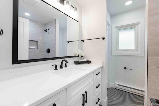 bathroom with tile patterned flooring, a baseboard radiator, tiled shower, and vanity