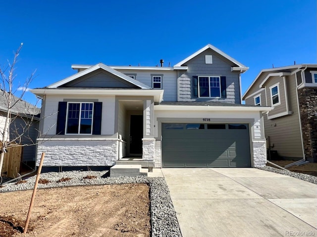 view of front facade with a garage, stone siding, and concrete driveway