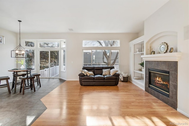 living room with a fireplace, hardwood / wood-style floors, and an inviting chandelier