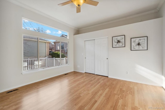 unfurnished bedroom with light hardwood / wood-style floors, a closet, ornamental molding, and ceiling fan