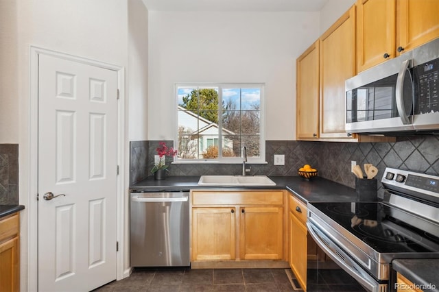 kitchen with decorative backsplash, sink, dark tile patterned floors, and appliances with stainless steel finishes