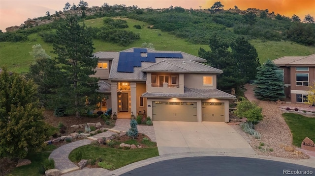 6338 Spotted Fawn Run, Littleton, CO 80125 - mediterranean / spanish house with a tiled roof, an attached garage, concrete driveway, solar panels, and stucco siding