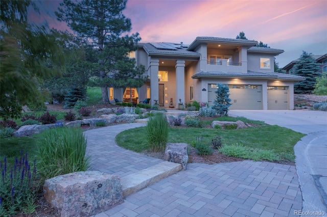 6338 Spotted Fawn Run, Littleton, CO 80125 - view of front of home featuring a balcony, an attached garage, roof mounted solar panels, a tiled roof, and driveway