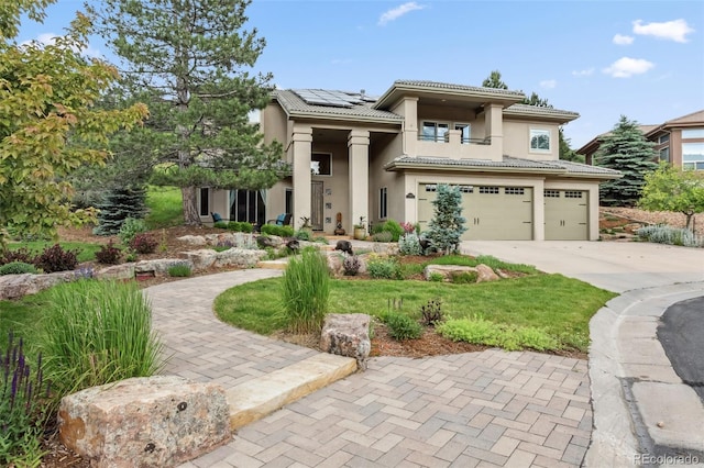 6338 Spotted Fawn Run, Littleton, CO 80125 - view of front facade with solar panels, an attached garage, driveway, a tiled roof, and stucco siding