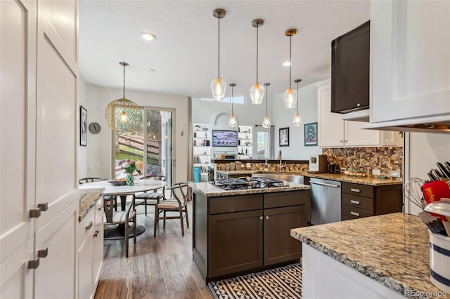 6338 Spotted Fawn Run, Littleton, CO 80125 - kitchen featuring stainless steel dishwasher, gas cooktop, white cabinetry, backsplash, and light stone counters