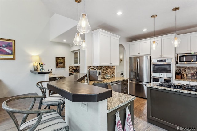 6338 Spotted Fawn Run, Littleton, CO 80125 - kitchen with appliances with stainless steel finishes, backsplash, wood finished floors, white cabinets, and recessed lighting