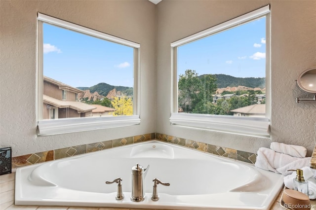 6338 Spotted Fawn Run, Littleton, CO 80125 - bathroom featuring a mountain view, a textured wall, and a garden tub