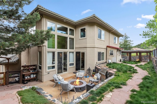 6338 Spotted Fawn Run, Littleton, CO 80125 - back of property with a fire pit, stucco siding, and a patio area