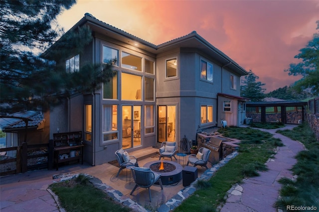 6338 Spotted Fawn Run, Littleton, CO 80125 - rear view of house featuring an outdoor fire pit, a patio area, and stucco siding