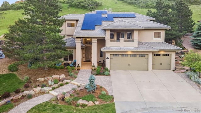 6338 Spotted Fawn Run, Littleton, CO 80125 - mediterranean / spanish-style house with a garage, a tiled roof, concrete driveway, stucco siding, and roof mounted solar panels