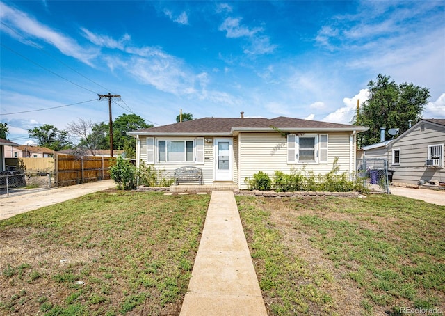 bungalow featuring a front lawn and fence