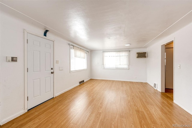 interior space with baseboards, visible vents, and light wood-type flooring