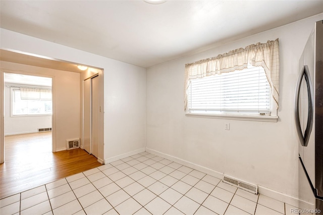 unfurnished room featuring light tile patterned floors, baseboards, and visible vents
