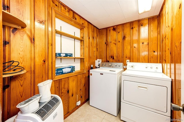 laundry room with wooden walls, light tile patterned floors, laundry area, and washer and dryer