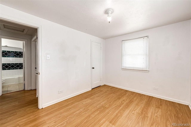 empty room featuring baseboards and light wood-style floors