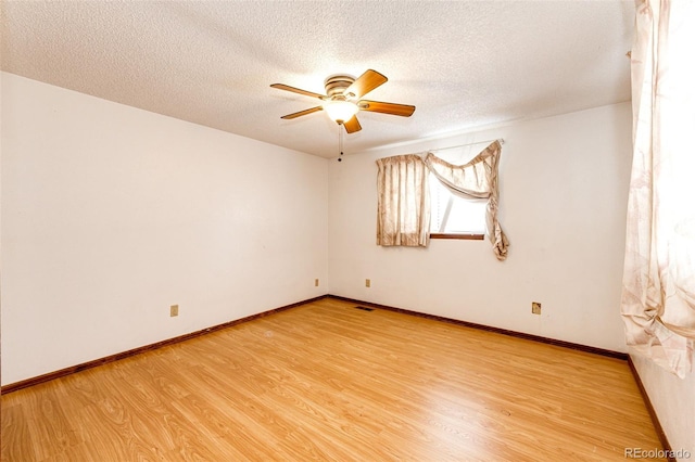 unfurnished room featuring baseboards, a textured ceiling, light wood-style flooring, and ceiling fan