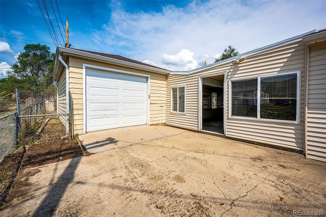 garage featuring fence and driveway