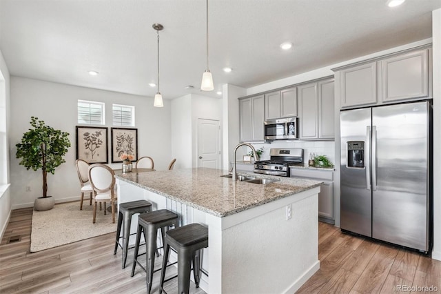 kitchen with light wood-style floors, a sink, appliances with stainless steel finishes, and gray cabinetry