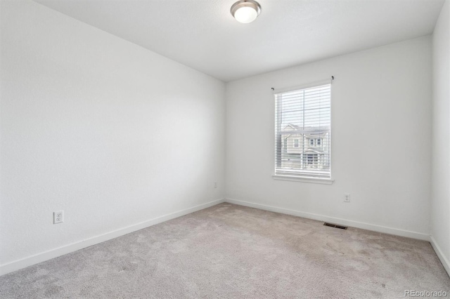 unfurnished room with baseboards, visible vents, and carpet