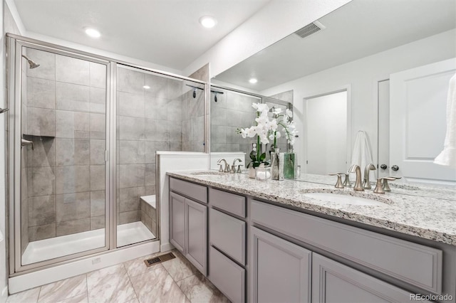 bathroom with double vanity, a sink, a stall shower, and visible vents