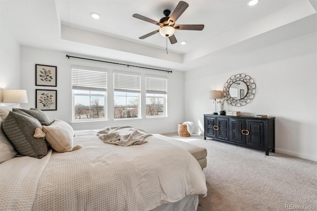 bedroom featuring baseboards, light colored carpet, recessed lighting, and a raised ceiling